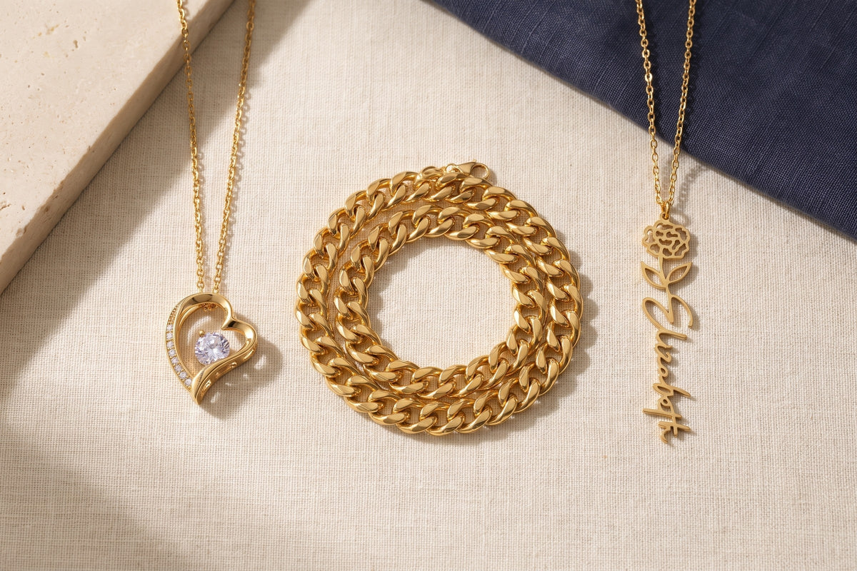 Three gold necklaces laid in a row on cream linen