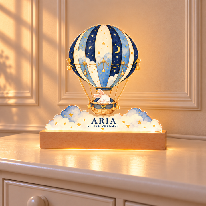 Aria Little Dreamer hot air balloon acrylic night light illuminated on an ivory nursery dresser