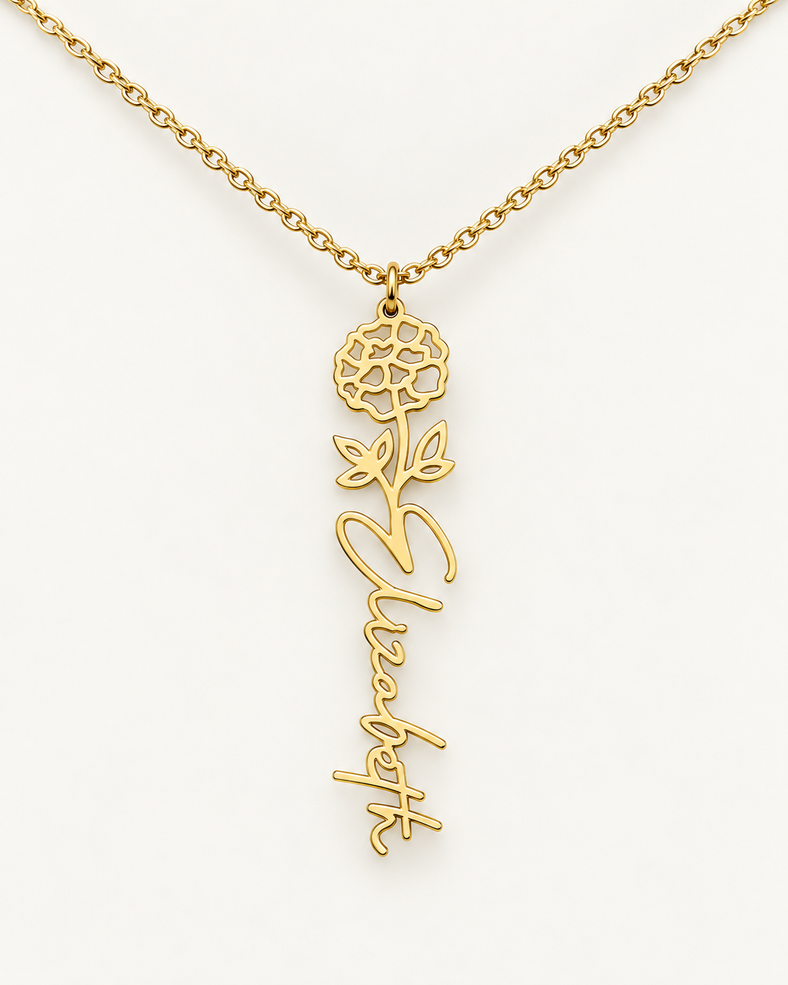 Gold-tone birth flower necklace with a chrysanthemum motif and vertical script name pendant on ivory.