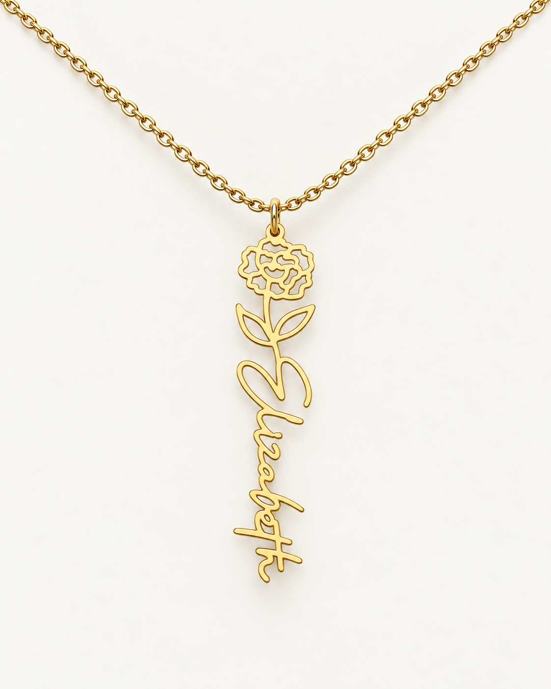 Gold-tone birth flower necklace with a rose motif and vertical script name pendant on ivory.
