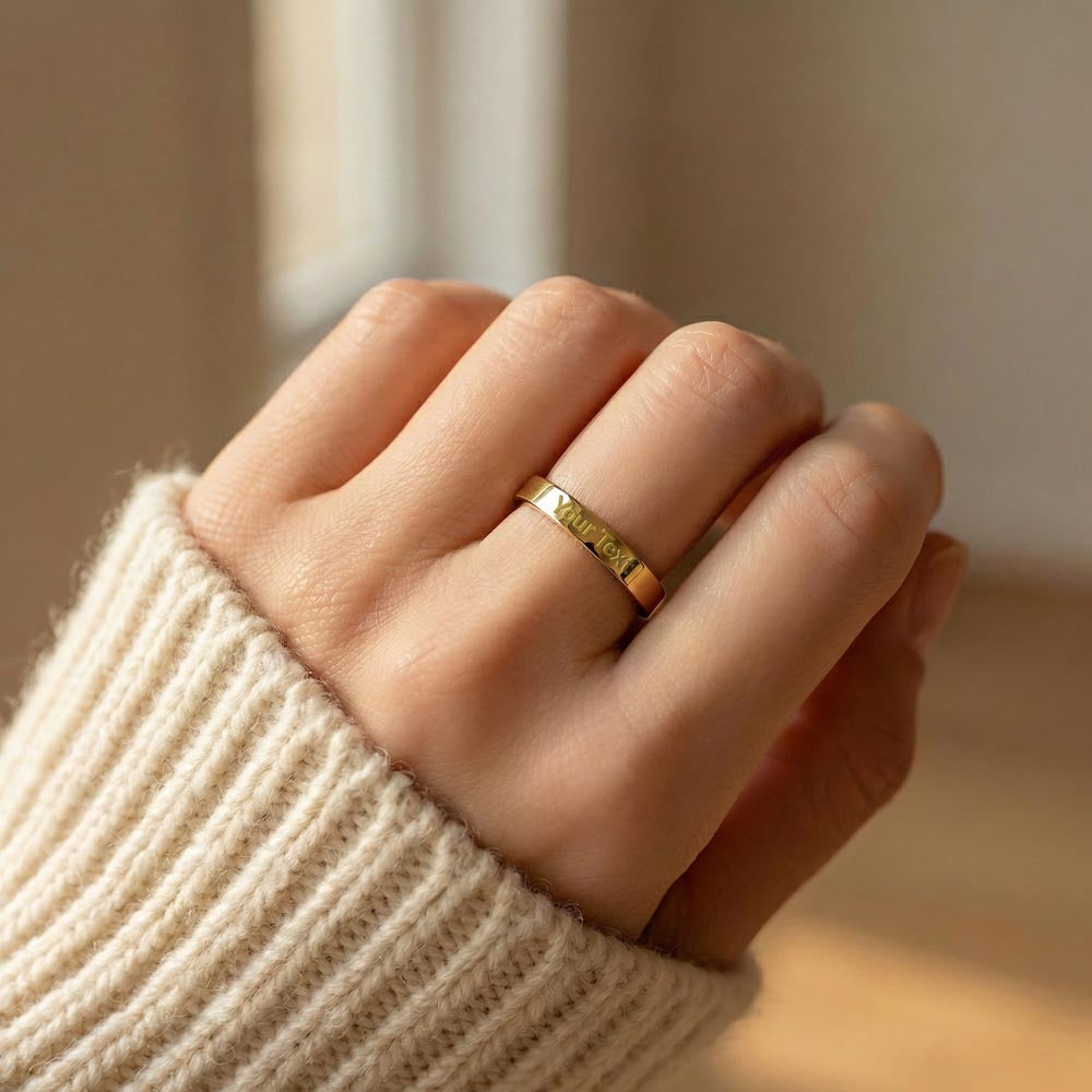 Gold-tone engraved ring worn with an ivory knit sleeve.