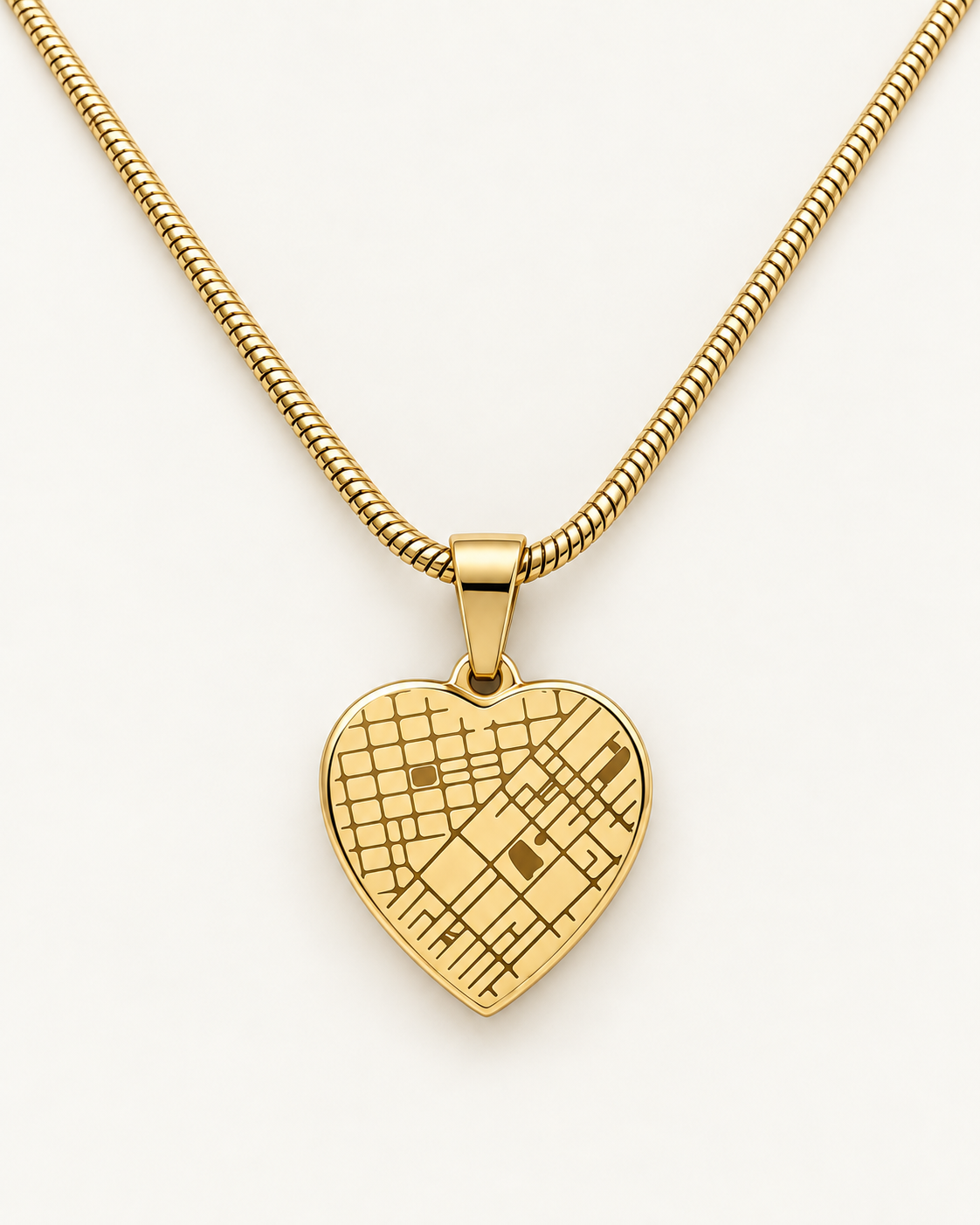 Gold-tone heart map necklace with an engraved street-map design on ivory.