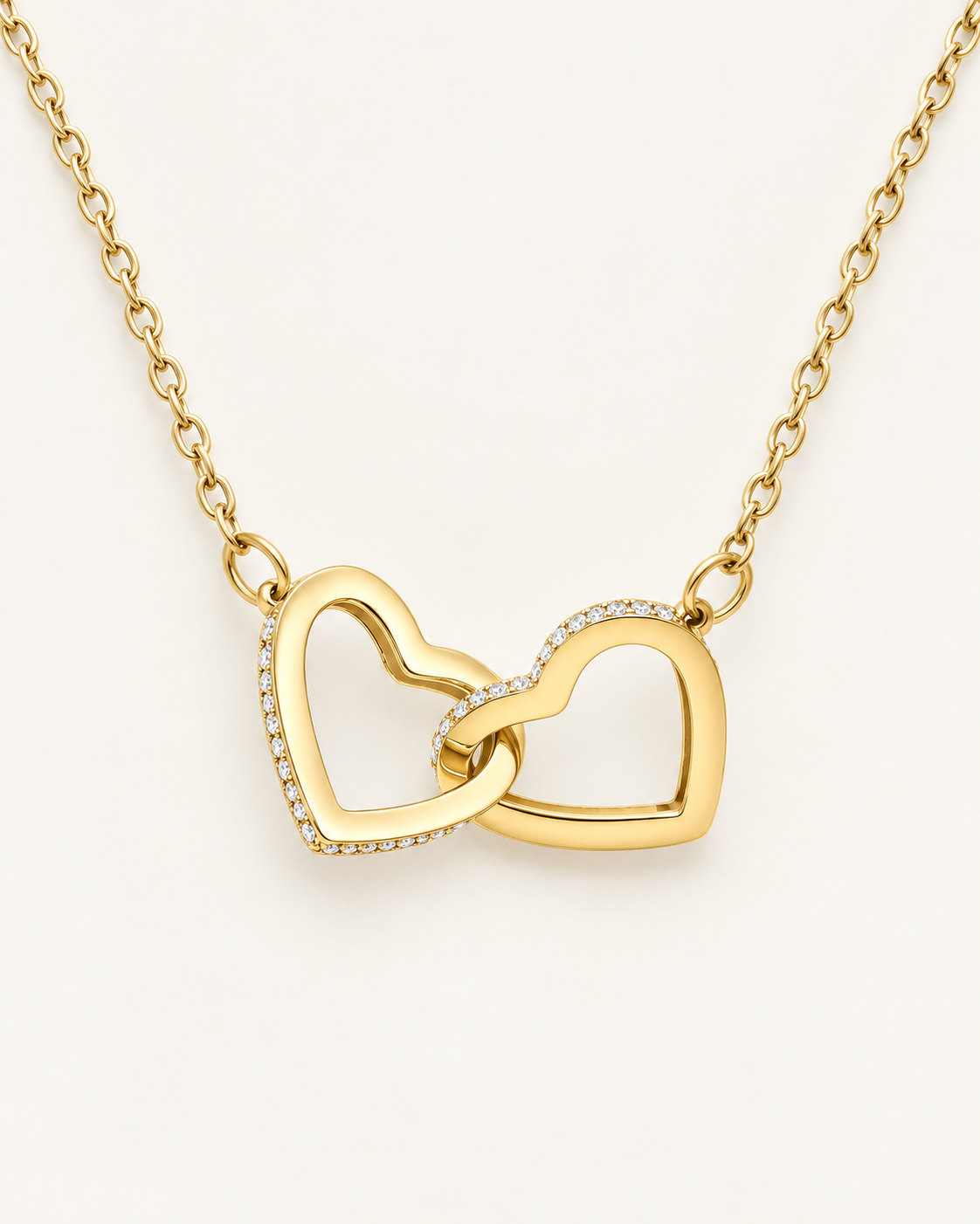 Close-up of gold-tone interlocking heart pendants with crystal accents.
