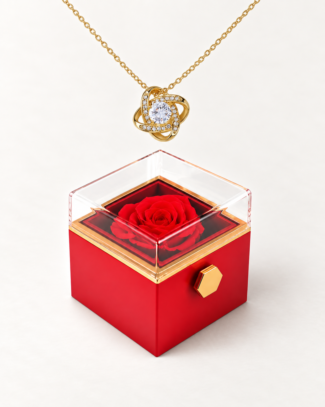 Gold-tone Love Knot CZ necklace displayed above a red rotating rose gift box.
