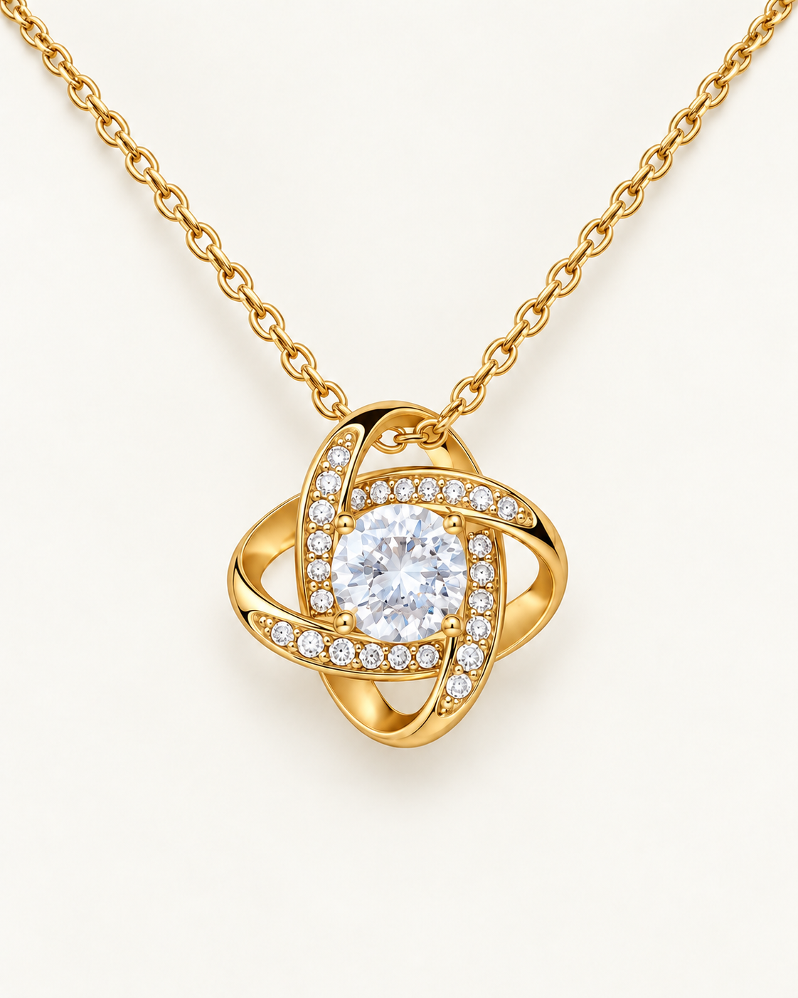 Close-up of a gold-tone Love Knot pendant with a round CZ center stone.