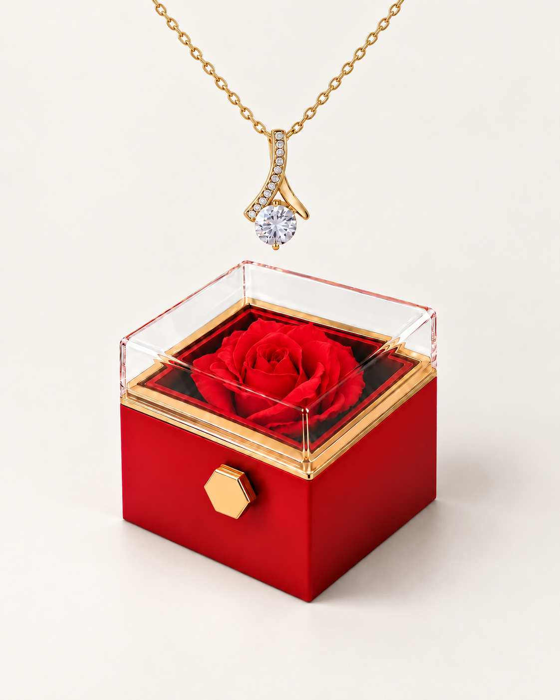 Gold-tone ribbon CZ necklace displayed above a red rotating rose gift box.