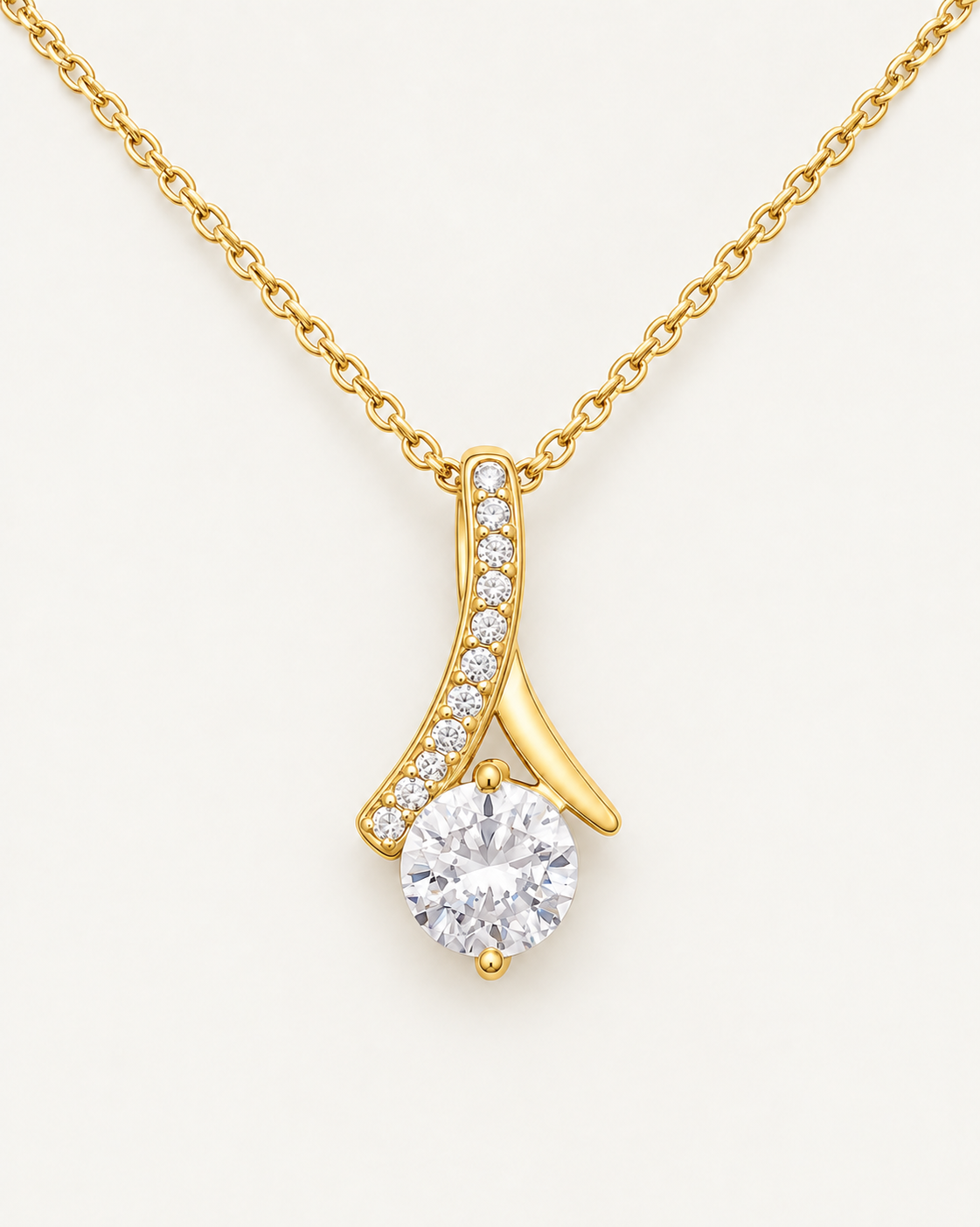 Close-up of a gold-tone ribbon pendant with a round CZ stone and crystal accents.