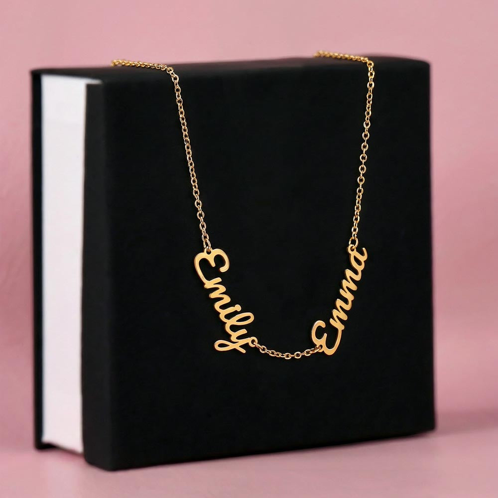Gold-tone two-name necklace displayed on a black gift box.