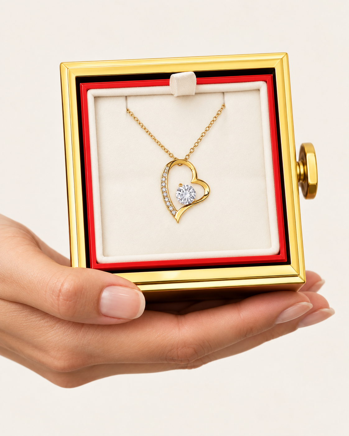 Hand holding an open rotating rose box with a gold-tone classic heart CZ necklace inside.