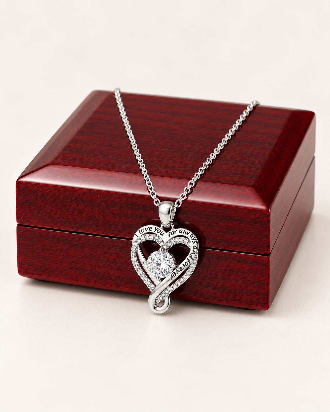 Love You Always silver-tone heart CZ necklace draped across a wooden gift box.
