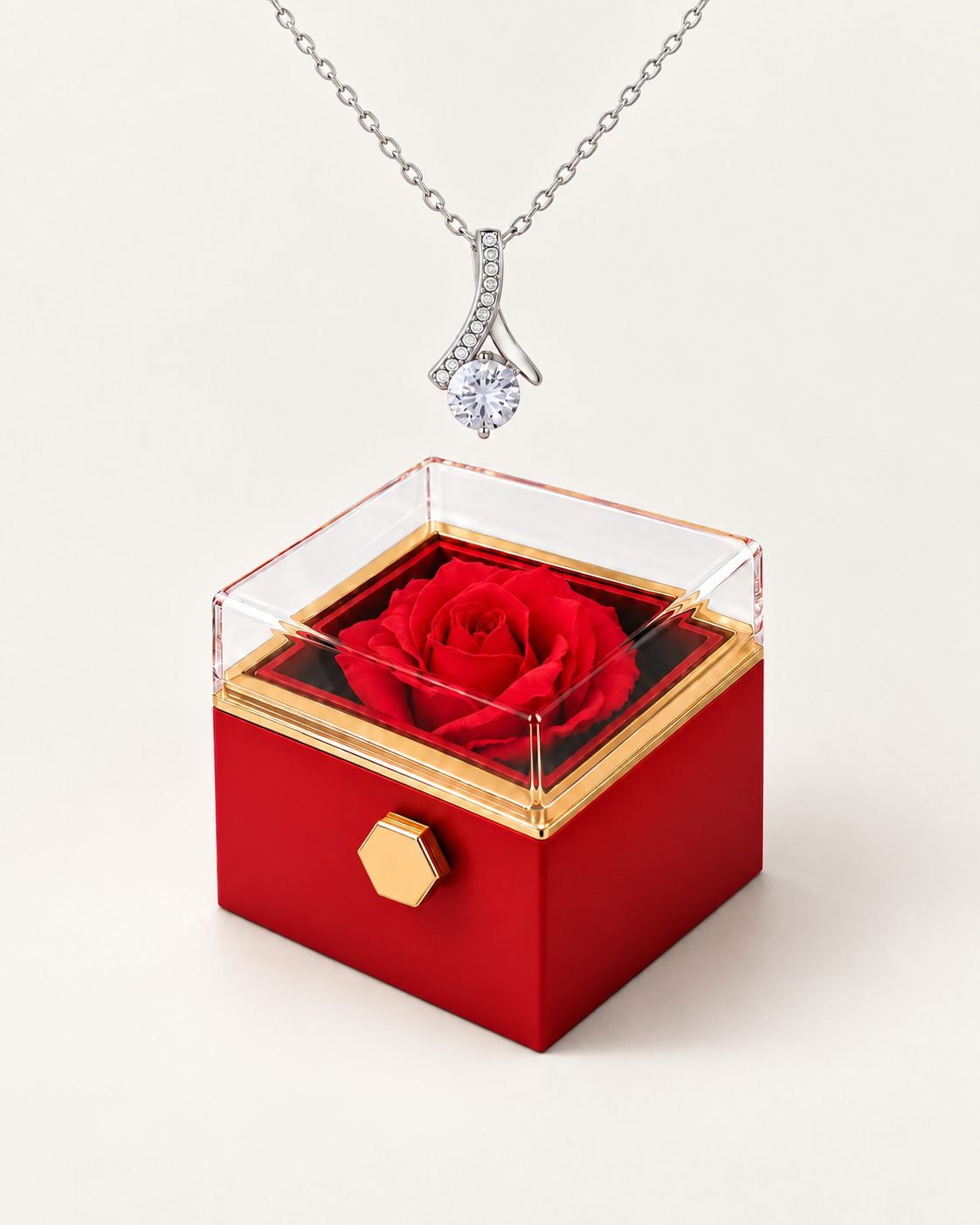 Silver-tone ribbon CZ necklace displayed above a red rotating rose gift box.