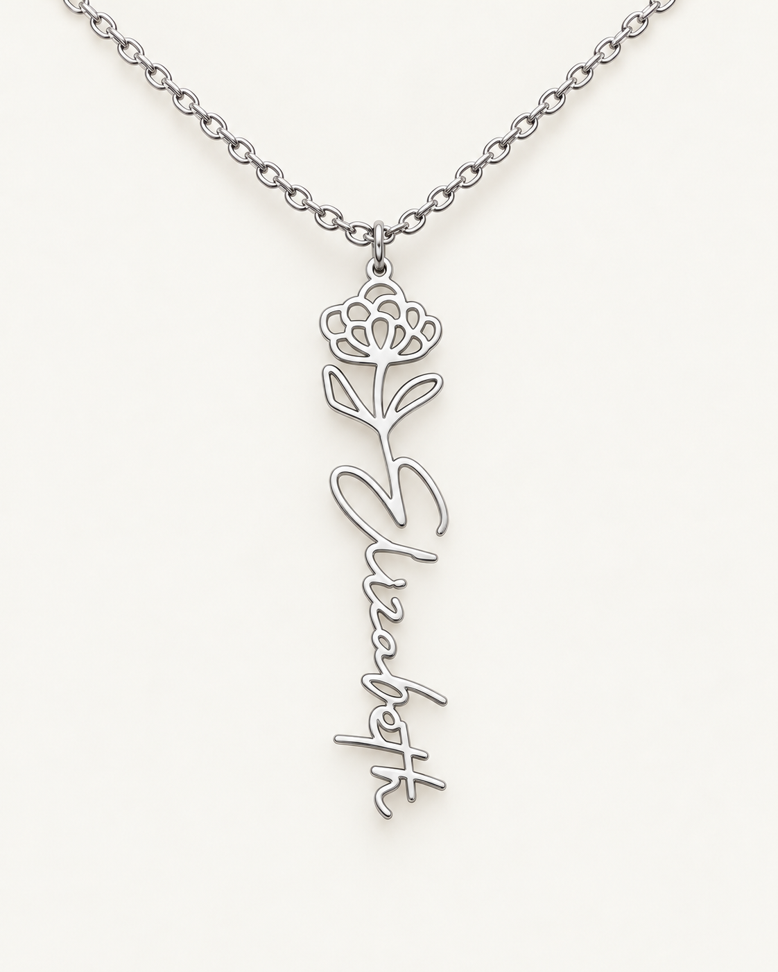 Silver-tone birth flower necklace with a chrysanthemum motif and vertical script name pendant on ivory.