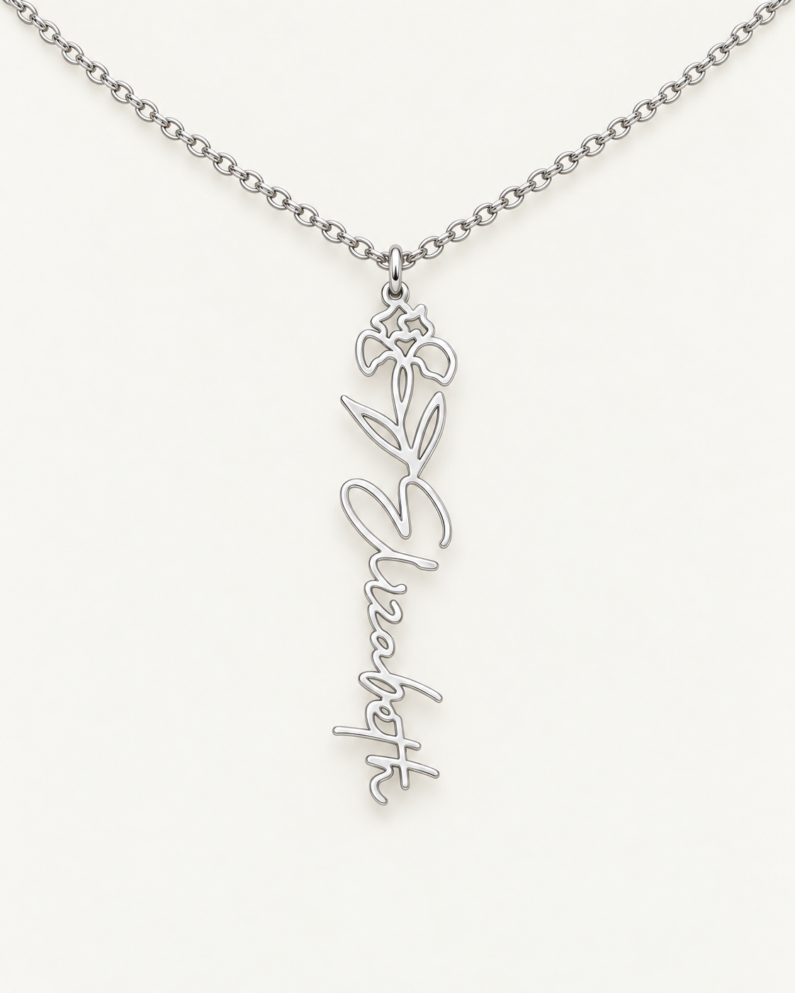 Silver-tone birth flower necklace with a iris motif and vertical script name pendant on ivory.