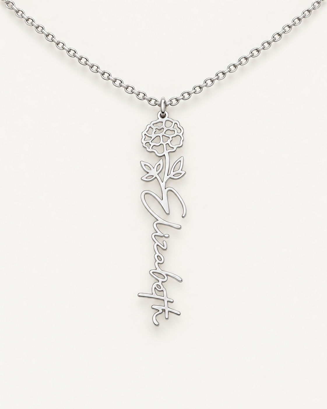 Silver-tone birth flower necklace with a marigold motif and vertical script name pendant on ivory.