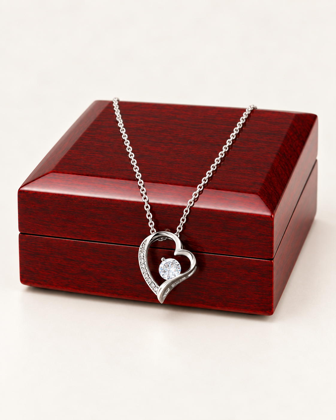 Silver-tone classic heart CZ necklace draped across a wooden gift box.