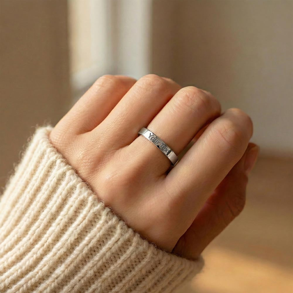 Silver-tone engraved ring worn with an ivory knit sleeve.