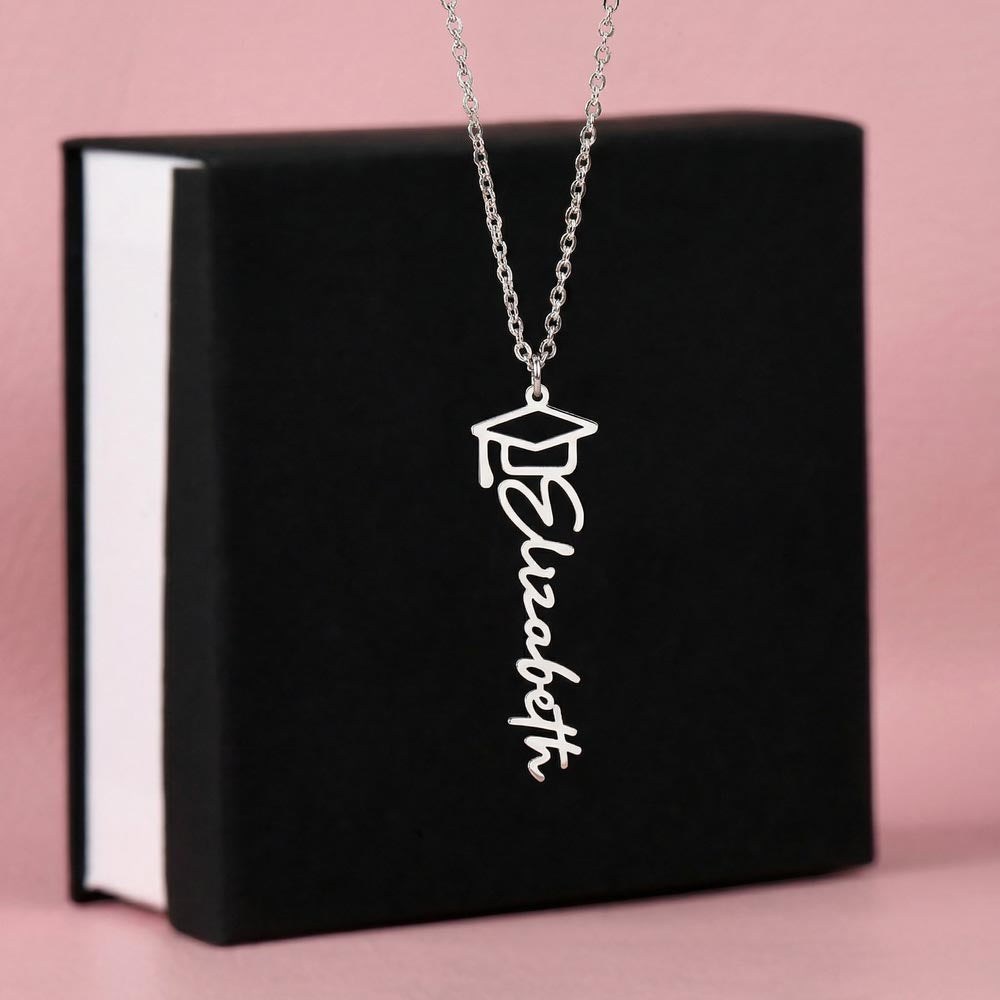 Silver-tone graduation name necklace displayed on a black gift box.