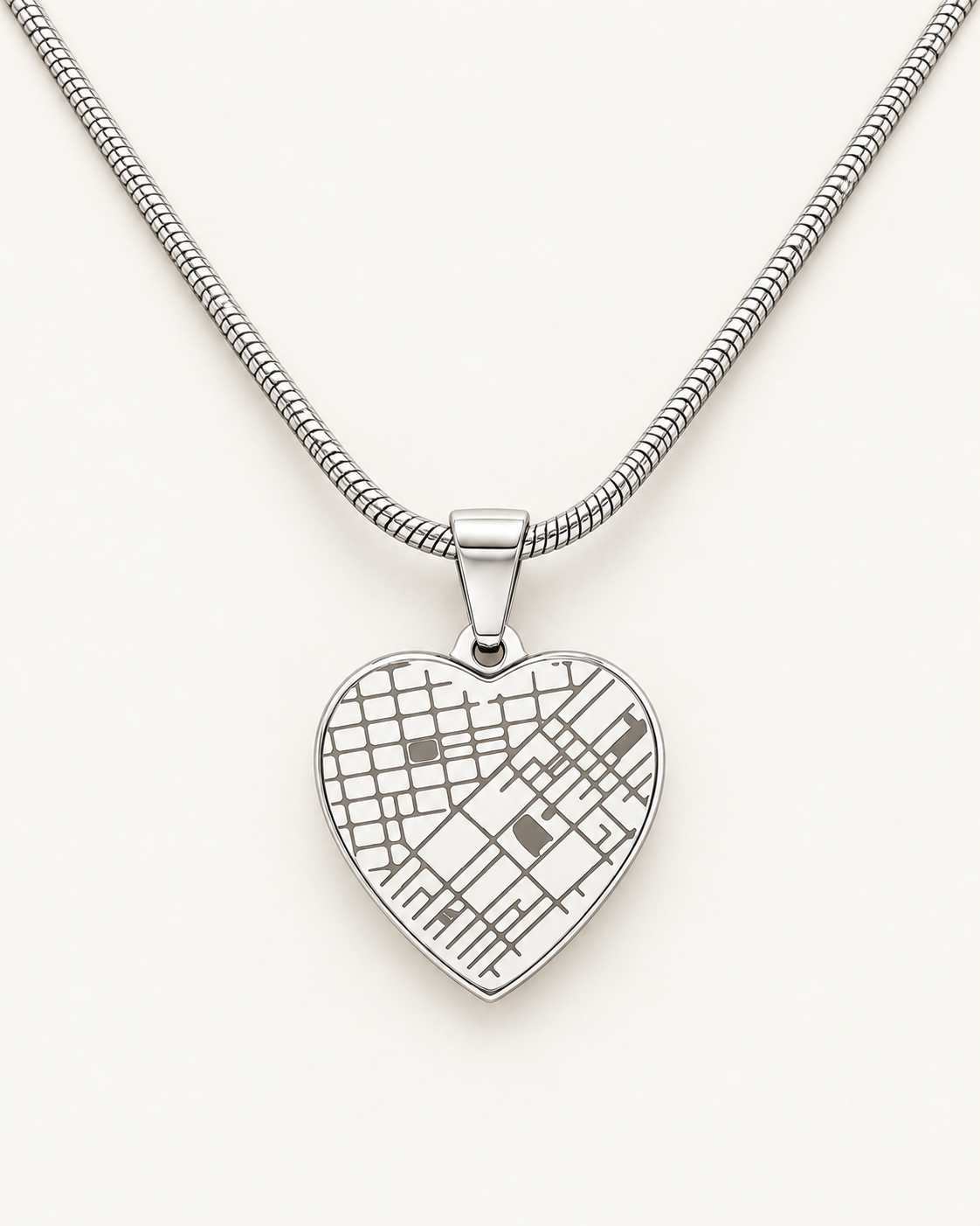 Silver-tone heart map necklace with an engraved street-map design on ivory.