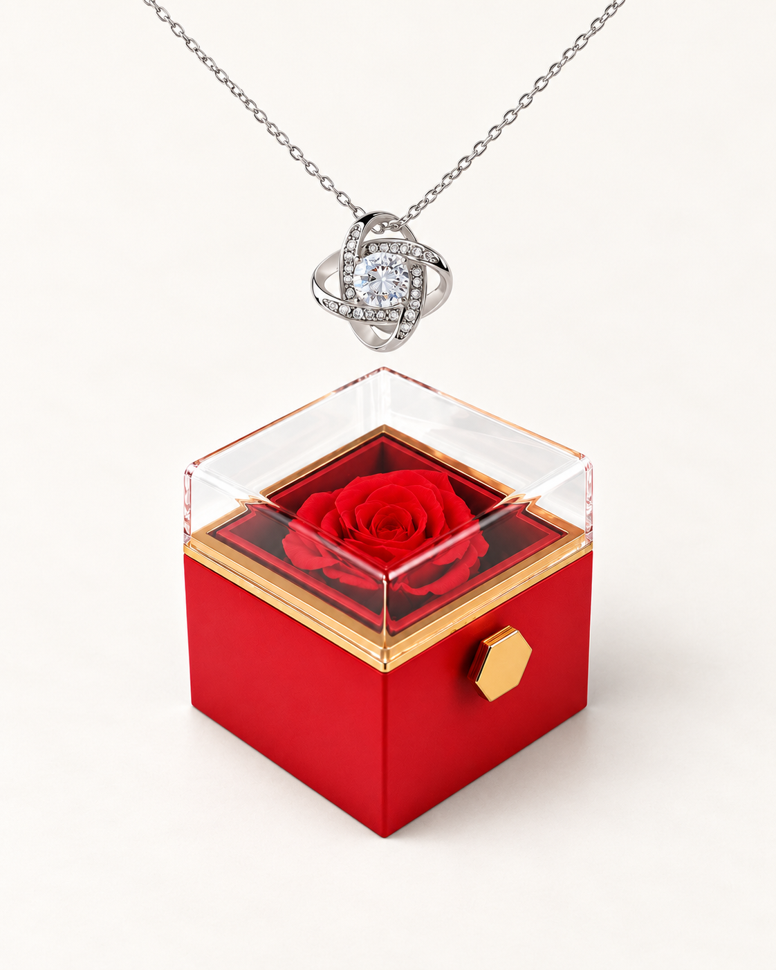 Silver-tone Love Knot CZ necklace displayed above a red rotating rose gift box.