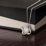 Silver-tone Love Knot CZ necklace displayed against a black gift box.