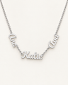 Silver-tone necklace with three connected script name pendants on an ivory background.