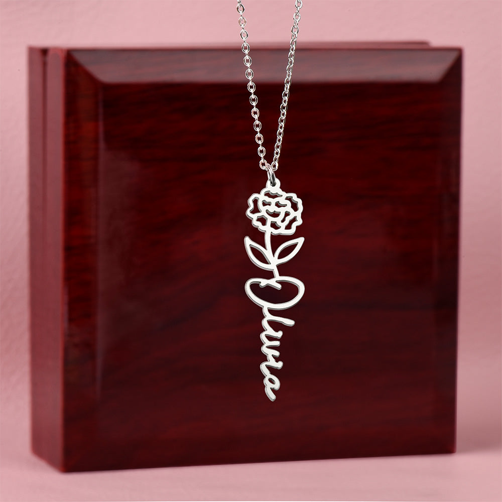 Silver-tone Olivia birth flower name necklace displayed on a wooden gift box.