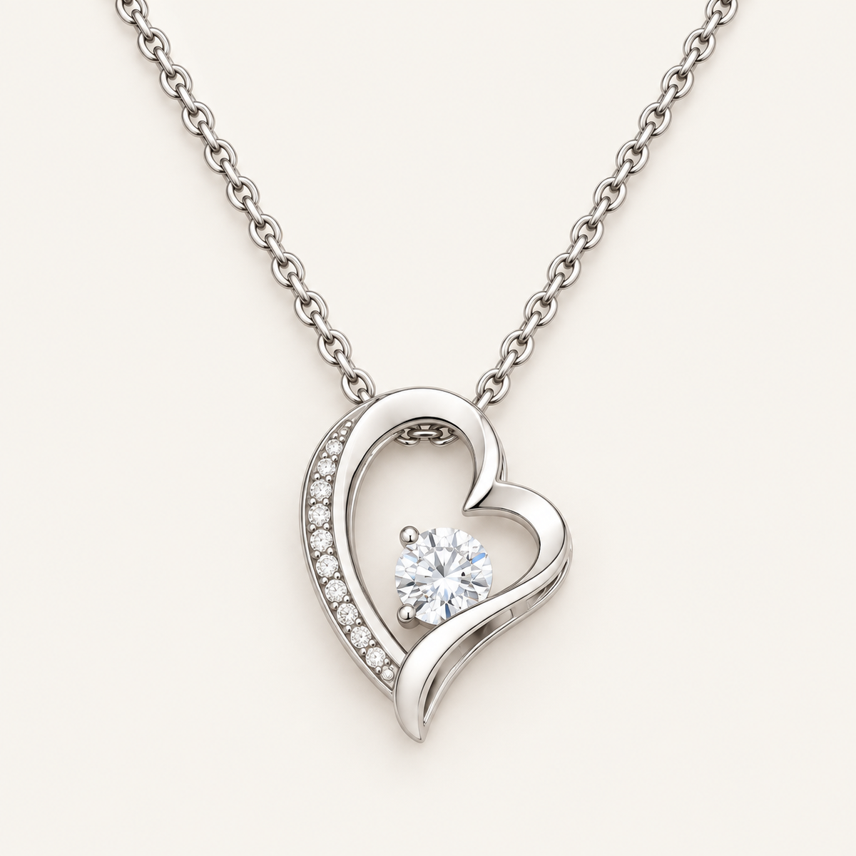 Close-up of a silver-tone open-heart pendant with a round CZ stone and crystal accents.