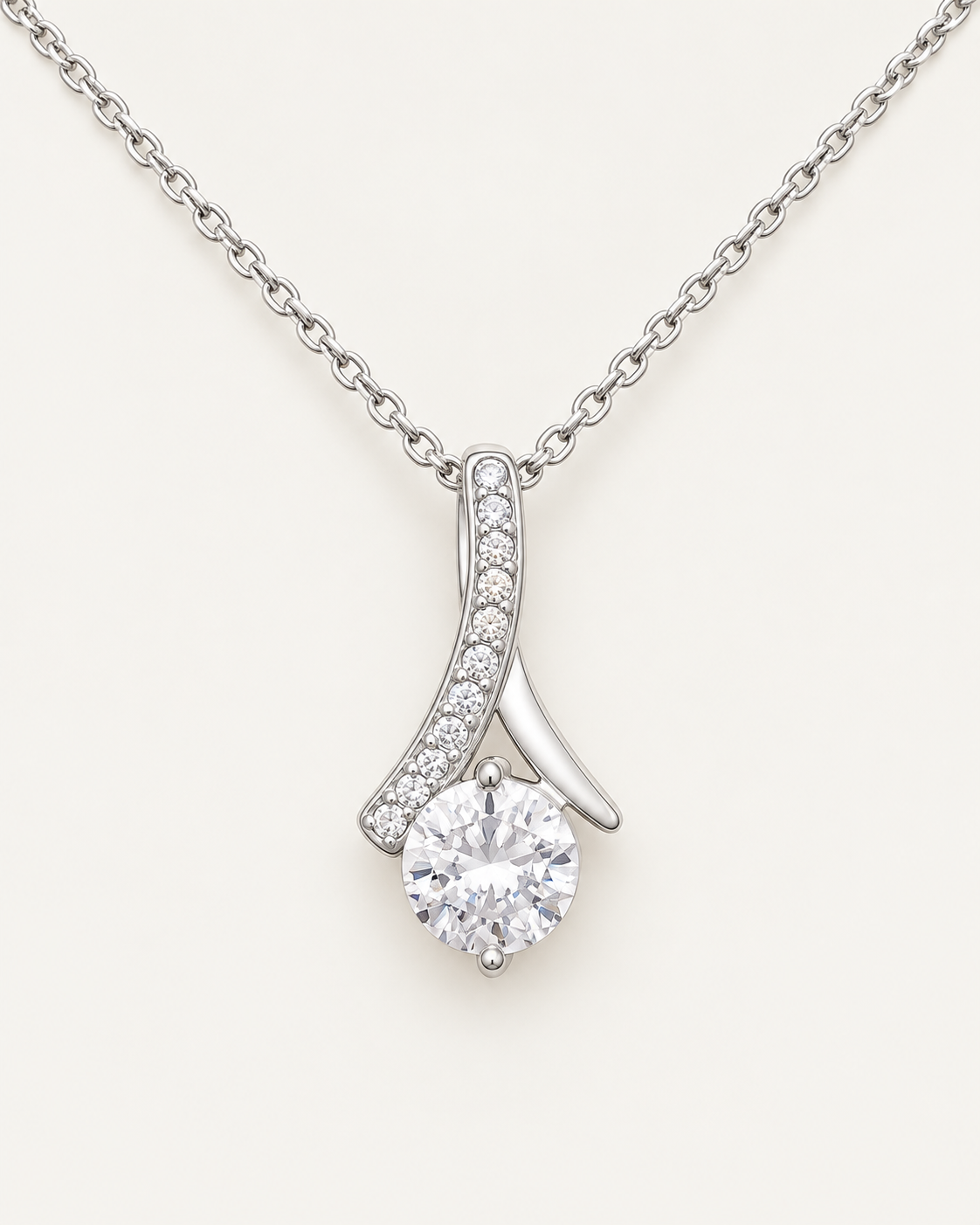 Close-up of a silver-tone ribbon pendant with a round CZ stone and crystal accents.