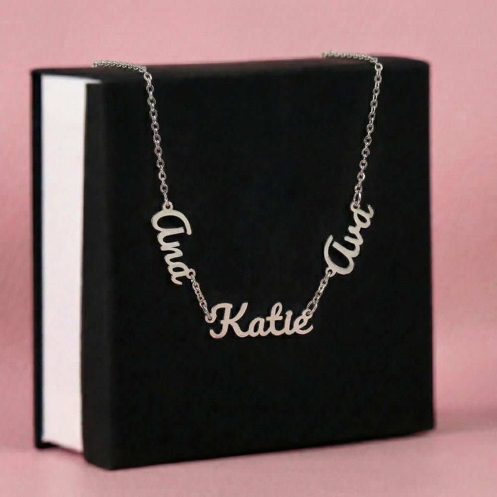 Silver-tone three-name necklace displayed on a black gift box.