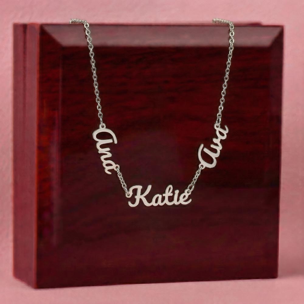 Silver-tone three-name necklace displayed on a wooden gift box.