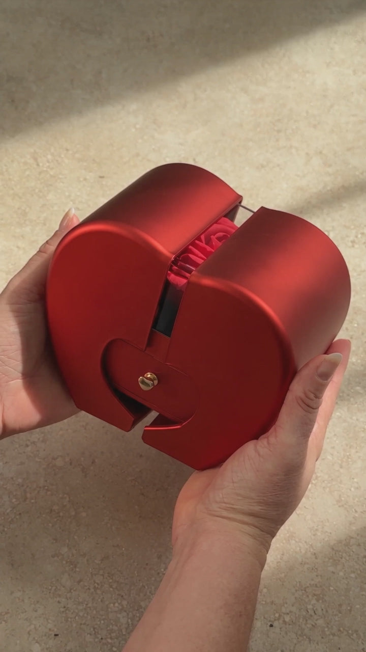 Product video showing the red heart-shaped rose gift box held in two hands.